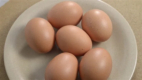 Close up top view of half a dozen brown eggs rotating. Seamless looping Stock Footage 71953592