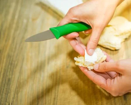 Close up top view of hands preparing snack of brie cheese with bread in the afte Stockfoto's