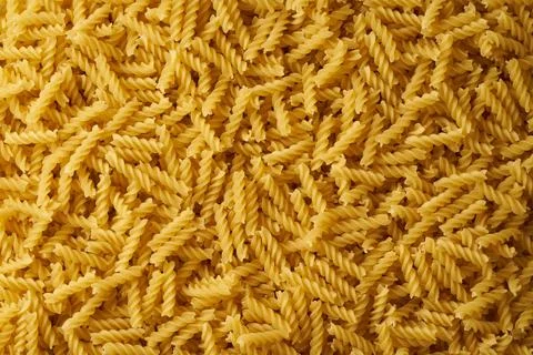 Close-up top view of heap of raw fusilli pasta. Stock Photos