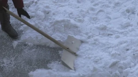 Close-up top view: a janitors shovel clearing freshly fallen white snow, co.. Video stock 330478453