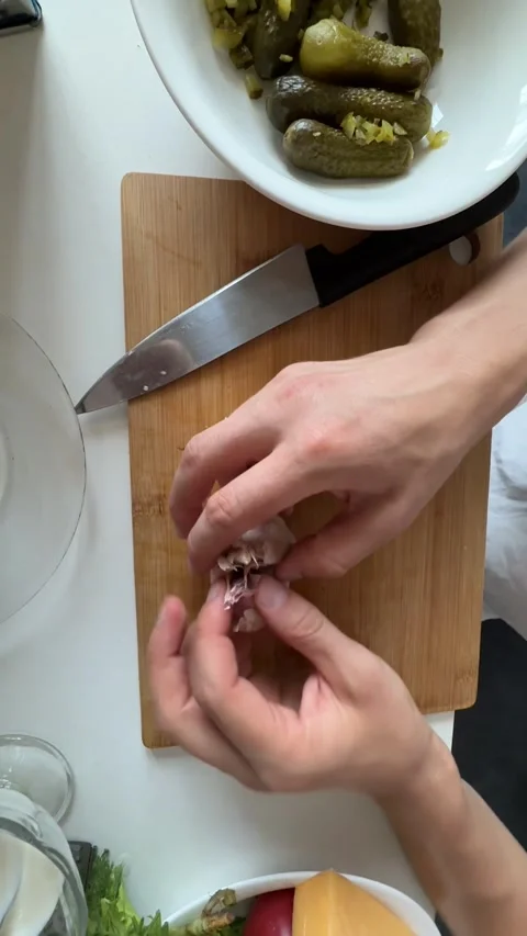 Close-up top view of male hands separating garlic cloves for salad dressing Stock Footage 337414409