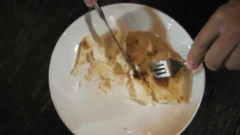 Close-Up Top View of a Man Cuts a Slice of Potato Casserole at a Night Cafe Stock Footage 97691587