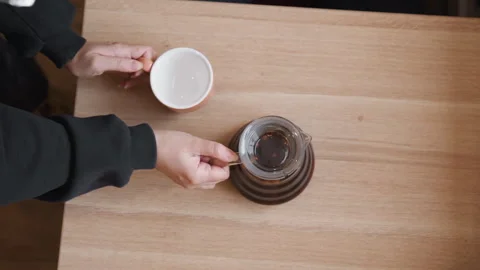 Close up top view person preparing coffee adding egg into glass carafe on light Stock Footage 345729037