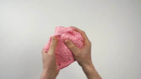 Close-up Top view: pink slime sticks to the hands, then hands stretch the slime Video stock 127388607