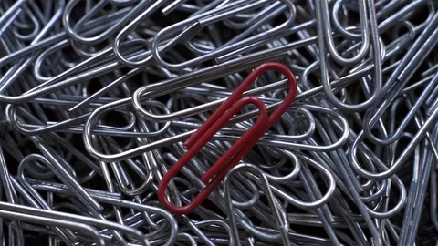 Close up top view of red paper clip on other gray. Tilt motion Stock Footage 72054501