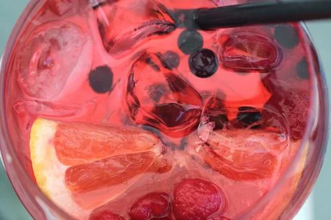Close-up top view of a refreshing pink gin cocktail with ice cubes and berrie Stock Photos