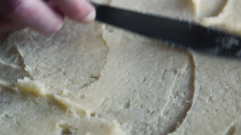Close-up top view of rolled dough being spread with butter for croissants.  Stock Footage 331851096