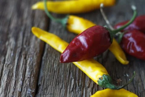 Close-up top view of several red and yellow hot peppers on a wooden table, se Stock Photos