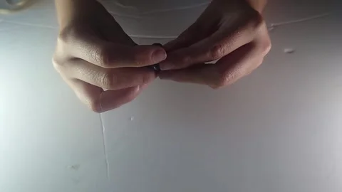 Close Up Top View Shot of Hands Threading String Through Large Button to Make Stock Footage 341879363