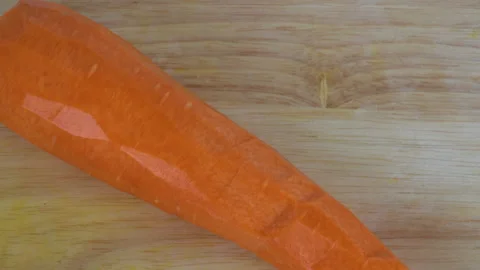 Close up top view, slow-motion, cutting a carrot in 2 pieces Видео 136715674
