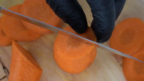 Close up, top view, slow-motion, cutting a carrot in 4 pieces 库存影片 136715769
