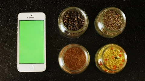 Close up top view of smart phone with blank green screen and hot spices herbs on Видео 89773764