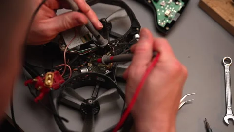 Close-up top view of technician using soldering iron and multimeter to repair Stock Footage 304864109