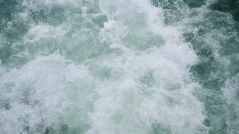 Close up top view of turbulent blue ocean water with white foam and bubbles.. Stock Footage 343115025