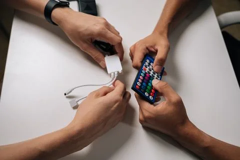 Close-up top view of two technicians connecting RGB led strip lights using Stock Photos
