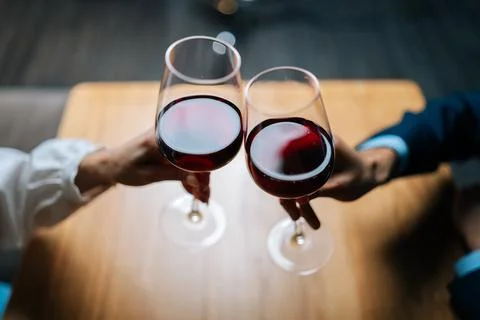 Close-up top view of unrecognizable loving man and woman clinking glasses with Stock Photos