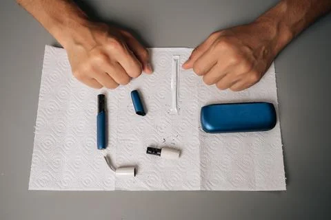 Close-up top view of unrecognizable man cleaning electronic cigarette with Stock Photos