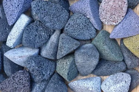 A close-up top view of various colored triangular abrasive finishing tumbling me Stock Photos