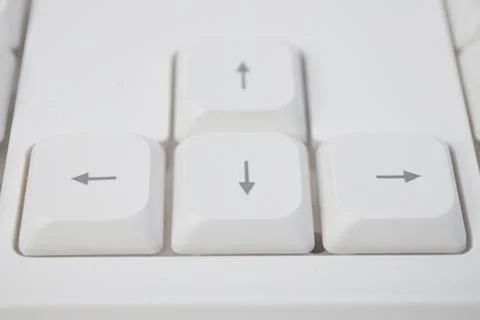 Close-up top view of white arrow keys (up, down, left, right) on a computer.. Stock Photos