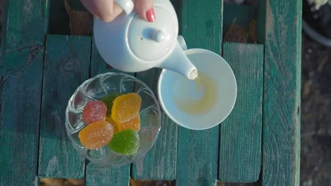 Close-up, Top View Woman's Hand Pours Green Tea into a Porcelain Cup Standing Stock Footage 97845182