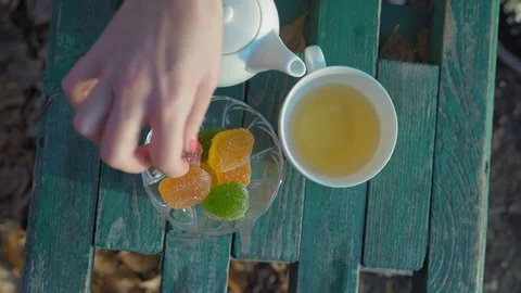 Close-up, Top View. Woman's Hand Takes a Cup of Green Tea and Marmalade Standing Video stock 97845950