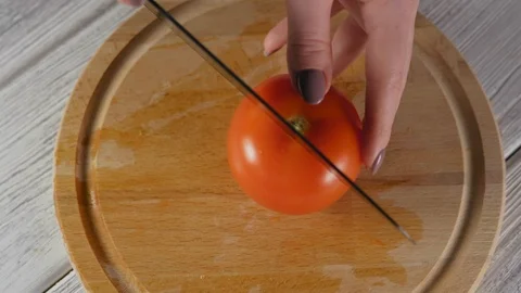 Close-up, Top View, Woman's Hands Cut Ripe Tomato with a Kitchen Knife Stock Footage 103639598