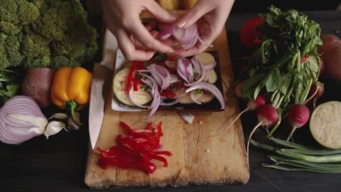 Close up of a top view of a woman's hands placing the chopped onions on the s Stock Footage 145242233