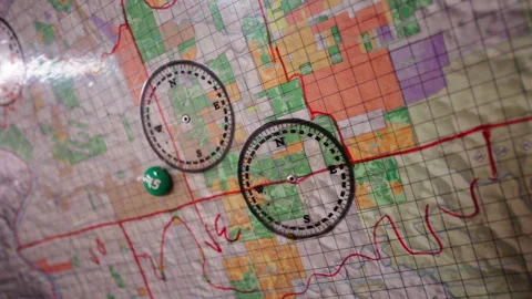Close-up of a topographical map with compass and marker placed on it for Stock Footage 302911217