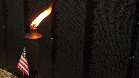 Close up of torch and flag next to Vietnam Wall That Heals. Stock Footage 47392019