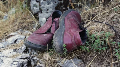 Close-up of torn leather shoes thrown into the street. Human garbage pollutes Stock Footage 204022383