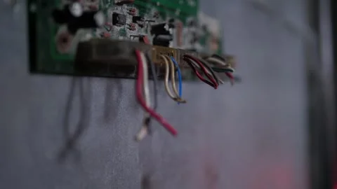 Close-up of torn wires from an old chip on the gray wall of a dark room. Stock Footage 310656335