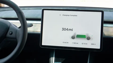 CLOSE UP: Touchscreen inside a Tesla notifies the car battery is fully charged. Stock Footage 114666194