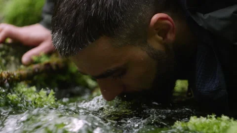 The close up of a tourist with a backpack drinks the life-giving water from a Stock Footage 204912804