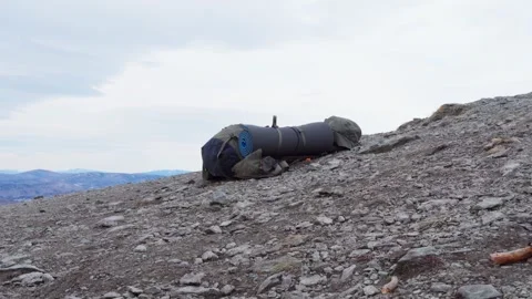 A close-up of a tourist backpack lying on top of a mountain. Video stock 270269136