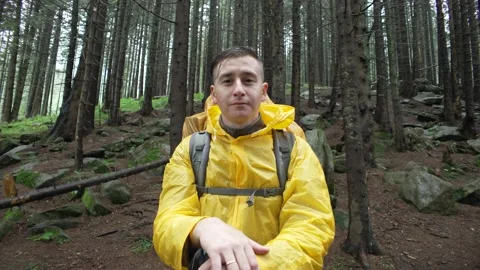 Close-up of a tourist in a raincoat with a backpack in the forest. Stock Footage 214328484