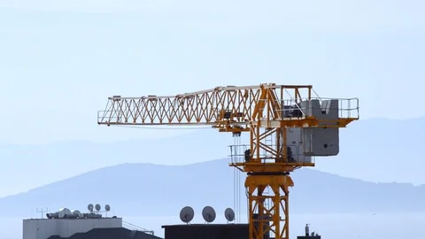 Close up of tower crane swinging slowly with wind in Kadikoy, Istanbul, Turkey Stock Footage 93544975