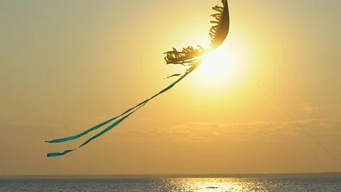 Close up toy kite flying high air in the wind against gold sunset sky background Stock Footage 99890812