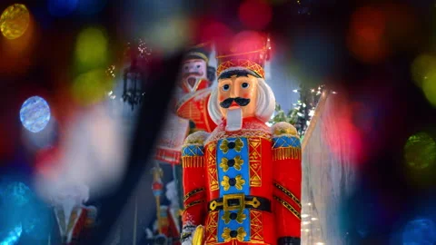 Close up of toy nutcracker soldier through colorful bokeh lights 스톡 동영상 331572286