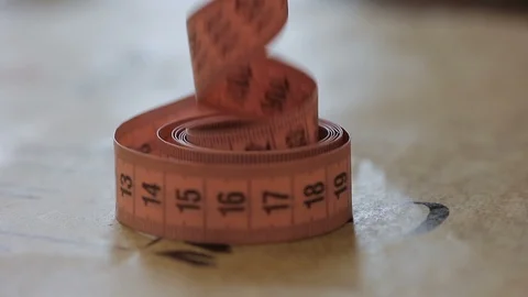 Close up of tpe-measure, which is being taken from the table by sewer in the Stock Footage 88570317