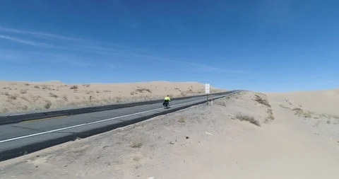 Close tracking of cyclist riding through North Algodones dunes drone aerial 4K Stock Footage 111309422