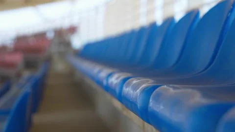 Close-Up Tracking Shot Along Row of Blue Stadium Seats With Shallow Depth of 動画素材 346654292