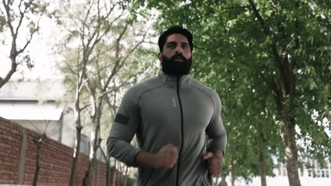 Close Up Tracking Shot of Athlete beard man jogging in park Video stock 145787773