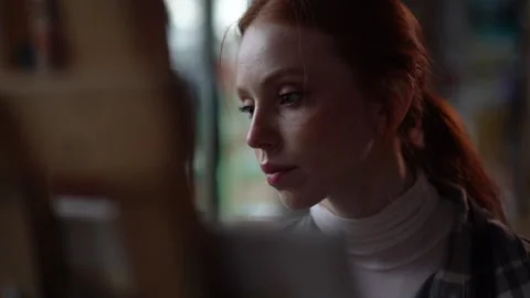 Close-up tracking shot of concentrated young female artist sitting in front of Stock Footage 166287821