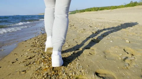 Close-up tracking shot of legs jogging girl on the beach. Runner's feet Stock Footage 196849015