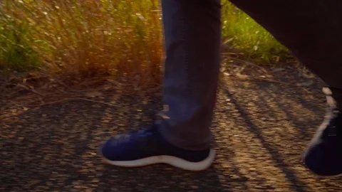 Close up tracking shot of legs walking on bush track Video stock 119349897