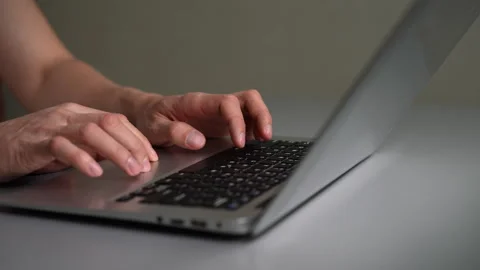 Close-up tracking shot of male hands typing on laptop keyboard and using Stock Footage 342758416