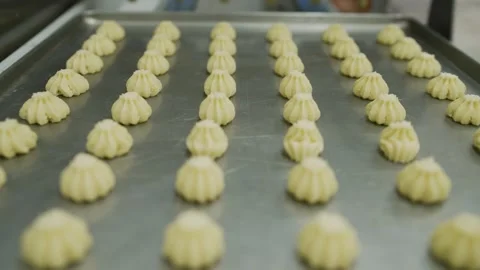 Close up tracking shot of piped cookie dough on a metal baking sheet in a Stock Footage 346729003