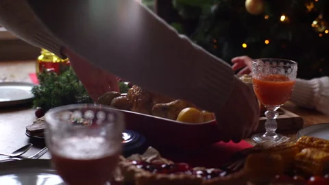 Close-up tracking shot of young man putting dish with baked hot turkey on dinner Video stock 163819821