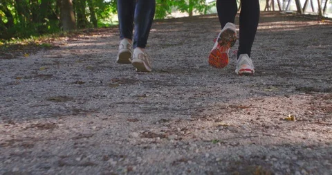 Close up tracking slow motion shot, two young pretty women running in park. Stock Footage 120235286