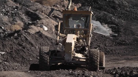 Close up of a tractor moving towards the camera at a coal mine in Greece Stock Footage 121014014